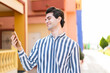 © luismolinero - Young handsome man using mobile phone at outdoors with happy expression