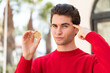 © luismolinero - Young handsome man holding a Bitcoin and having doubts