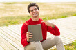 © luismolinero - Young handsome man holding a tablet at outdoors and pointing it