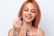 © luismolinero - Young Russian girl isolated on white background holding a serum while smiling. Close up portrait
