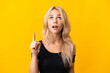 © luismolinero - Young Russian woman isolated on yellow background pointing up and surprised