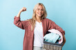© luismolinero - Young Russian woman holding a clothes basket isolated on blue background doing strong gesture