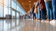 © Gulnaz - A group of people are standing in line at an airport. The image is blurry and shows the people's legs and feet. Scene is busy and hectic, as the people are waiting in line to board a plane