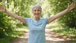 © Vasiliy - Smiling senior woman with arms outstretched on a forest path. Mature female with short grey hair enjoying nature. Healthy lifestyle and wellness concept for active aging