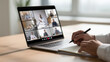 © Lumi Stock Studio - A high-quality corporate photo of a professional's hands taking notes during a multi-person online video conference on a laptop, representing remote work and digital collaboration.