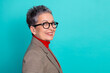 © deagreez - Senior businesswoman with short gray hair wearing glasses and a plaid blazer with red turtleneck smiles blue background for lifestyle advertising
