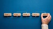 © NURAESHA - Hand placing wooden block with win text in a sequence of start plan work check win on blue background