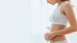 © Eve - Woman in white underwear holding a daisy flower near her stomach, side view, concept of healthy digestion, female hygiene, gynecological wellness, and natural skincare on light background.