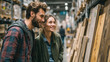 © Natalya - Happy young couple choosing wood planks in a hardware store. Man and woman shopping together for a home improvement DIY project