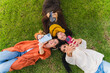 © pablo - Three young women friends lying on green grass taking selfies with smartphones