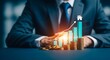 © MarufIslam - Businessman analyzing financial growth with bar chart and coins on a table