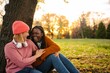 © Jelena - Diverse women friends laughing together enjoying autumn park