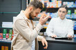 © Serhii - Customer discussing symptoms with pharmacist in drugstore