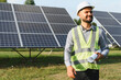 © Serhii - Engineer smiling standing at solar panel farm