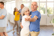 © JackF - Positive active elderly couple enjoying slow foxtrot in dance studio. Amateur social dancing concept