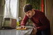 © Miljan Živković - Man intently cleaning kitchen counter with yellow cloth