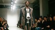 © Vitalii But - Man walks on runway wearing a tie and unique fashion design during a fashion show event at an urban location in the evening