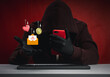 © tete_escape - Scammer in hoodie using red mobile phone to commit online fraud, including romance scams, money traps, and phishing messages. Concept of digital deception, emotional manipulation, and cybercrime.