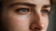 © Bussakon - A close up of a person s eye showing a tear rolling down their cheek conveying a sense of sadness or deep emotion