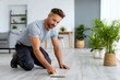© kardaska - Man installing new laminate flooring on floor at home