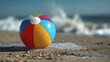© Tanu - Beach ball is on sand near ocean waves during sunny day at the beach with clear blue sky in background capturing summer fun and playful moments