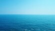 © pattaphorn - Tranquil Blue Ocean Horizon Under Clear Skies Reflecting Soft Sunlight in a Serene Landscape