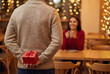 © Stockphotosbysumit - Man hiding red gift box behind back to surprise girlfriend on valentine's day