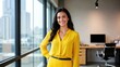 © Babb - Confident hispanic female young professional in yellow outfit standing in modern office