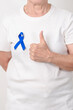 © Jo Panuwat D - Elderly with dark Blue or Navy blue Ribbon for concept of March Colorectal and Colon Cancer Awareness month, May Arthritis awareness, July Juvenile arthritis and Childhood. Health and world cancer day
