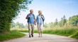 © NeuroCake - Senior couple hiking on a nature trail. Happy elderly man and woman walking with backpacks and holding hands. Active retirement lifestyle
