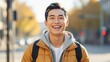 © Parvin - Young asian man smiling outdoors in autumn with a backpack on