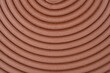 © nahhan - A close up top view of a brown adhesive foam strip for window sealing arranged in a concentric circular pattern