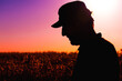 © Bits and Splits - Back lit silhouette of a male farmer standing in blooming cultivated rapeseed crop plantation field