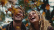 © Jhati - A young couple laughs joyfully together outdoors on an autumn day surrounded by falling leaves