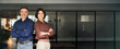 © insta_photos - Happy executive managers, two business man and woman leaders entrepreneurs, corporate partners business owners professional work team standing arms crossed in office looking at camera. Portrait.