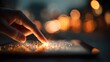 © horizon - Close-up view of a finger touching a glowing digital tablet screen with detailed skin texture against a warm background of soft bokeh lights.