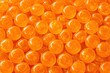 © Irina - Close-up view of numerous glossy orange marbles arranged closely together, showcasing their smooth surfaces and vibrant color in a detailed composition