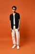 © LIGHTFIELD STUDIOS - Stylish young man with curly hair poses confidently in a vibrant studio setting