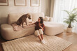 © Big Shot Theory - pet training session in cozy living space, woman helps dog practice jumping on sofa attentively