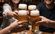 © YiuCheung - Friends toast with beer glasses, celebrating together in a warm, social gathering.