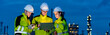 © BESTIMAGE - Petrochemical industry night engineer teamwork working on laptop Team of Petroleum in Glowing Workwear Collaborating oil refinery plant construction site at night