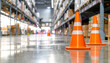 © miracle - Orange traffic cones sit on the floor in a warehouse aisle between shelves filled with boxes