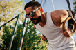 © kleberpicui - Active adult man exercising outdoors in an urban park. Concepts of physical activity, strength training, healthy lifestyle, outdoor workout, motivation and well being.