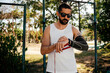 © kleberpicui - Adult man adjusting sports gear before exercising outdoors in a park. Concepts of physical activity, injury prevention, preparation and healthy lifestyle.