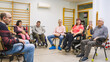 © DMegias - Adults with varying disabilities engaged in a group therapy discussion, fostering community, rehabilitation, and inclusion