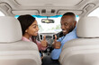 © Prostock-studio - Great Perfect Car. Smiling Black Couple Showing Thumbs Up Sign Gesture, Sitting In New Automobile Buying Modern Vehicle In Dealership Store Or Enjoying Vacation, Turning Back At Passenger's Seat