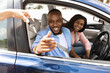 © Prostock-studio - Car Sales. Manager giving new auto key to happy young black couple at dealership store, selective focus. Excited African American customers buying vehicle from salesman seller at automobile showroom