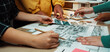 © InfiniteFlow - A vibrant collaboration scene where diverse individuals engage around architectural plans and sketches, discussing design ideas and strategies in a creative workspace. SACTR