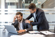 © Liubomir - Business professional experiencing stress and receiving empathetic support from a colleague, finding resolution and help in a challenging office environment while working on a laptop