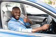 © Prostock-studio - Great Car. Happy African American Man Showing Thumbs Up Sign Gesture, Sitting In New Automobile Buying Modern Vehicle In Dealership Store Or Enjoying Vacation, Looking Out Of Window. Selective Focus